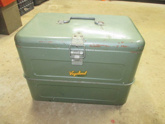 Green metal toolbox with a handle and latch, showing rust spots and a 'Vagabond' label