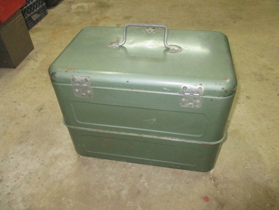 green metal toolbox with a handle on top and hinges on the sides