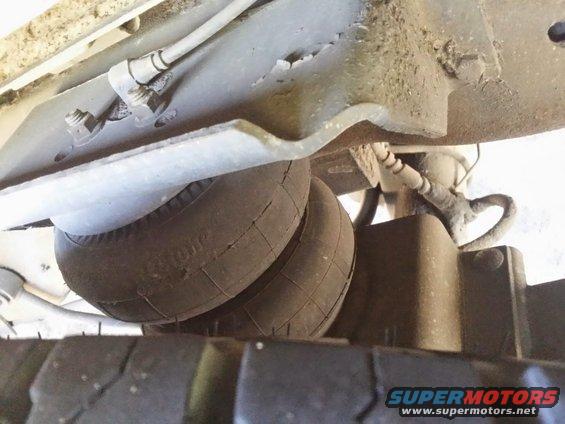 Underside view of a vehicle's air suspension bellows and tire tread