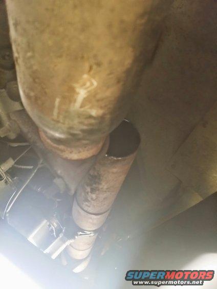 Exhaust pipe with white markings and a clamp, viewed from below