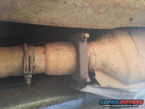 Exhaust pipe with clamp and catalytic converter underside of vehicle