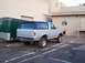 1990 Ford Bronco - This 1990 Ford Bronco is silver with a black top and is parked next to a green trailer.