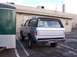 1990 Ford Bronco - This 1990 Ford Bronco is seen from the rear, parked beside a green trailer in a lot.