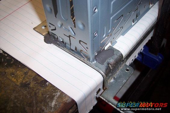 Metal bracket attached to a piece of lined paper, with a date stamp '08/23/2014'