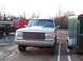 1990 Ford Bronco - Silver 1990 Ford Bronco with custom grille, parked outdoors with other vehicles and trailers.