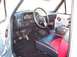 1990 Ford Bronco - The interior of a truck features a dashboard with gauges, a steering wheel, and custom two-tone seats with red accents.