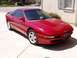 1995 Ford Probe - A red 1995 Ford Probe is parked in front of a house on a sunny day.