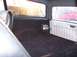 1990 Ford Bronco - The interior of a 1990 Ford Bronco shows black carpet and seats, with an amplifier mounted on the side panel.