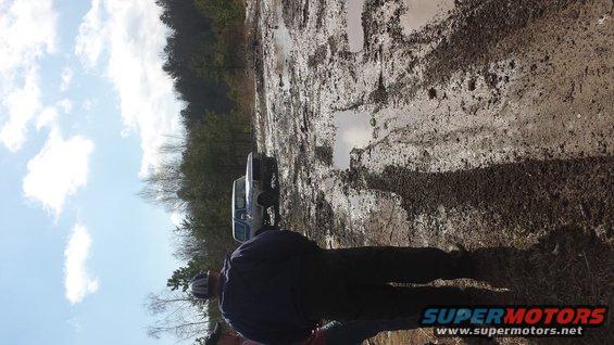 1979 Ford Bronco and another truck stuck in mud on a trail