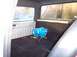 1990 Ford Bronco - The interior of a vehicle shows a blue nitrous oxide tank and a yellow tool on the carpeted floor.