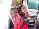 1990 Ford Bronco - The interior of a vehicle features custom seats with red flame accents and a central console with multiple cup holders.