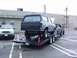 1990 Ford Bronco - A gray 1990 Ford Bronco is loaded onto a trailer, with a pickup truck ready to tow it.