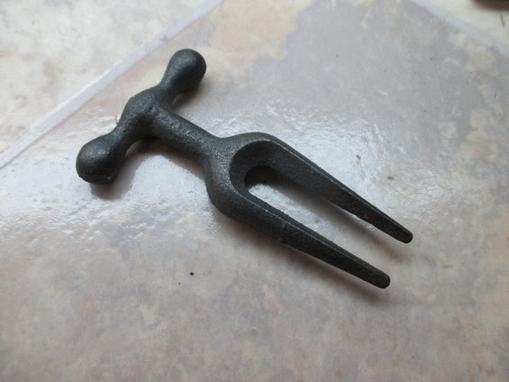 metal golf ball divot repair tool with a T-shaped handle and two prongs