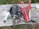 2006 Nissan Titan - A pair of vehicle struts and a red spring compressor tool are laid out on a weathered wooden surface, with grass in the background.