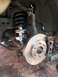 2006 Nissan Titan - The front suspension and brake assembly of a vehicle, showing a new shock absorber and rotor.