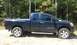 2006 Nissan Titan - This blue pickup truck, identified by its V8 TITAN badging, is seen from the side in an outdoor setting.