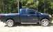 2006 Nissan Titan - A side profile of a dark blue 2006 Nissan Titan pickup truck is shown parked outdoors with trees in the background.
