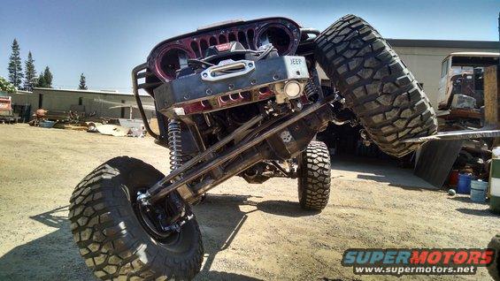 Modified Jeep CJ-series with large off-road tires, lifted suspension, and a winch on the front bumper