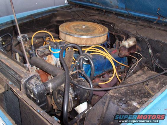 engine bay with blue engine block, yellow spark plug wires, and a rusty air cleaner