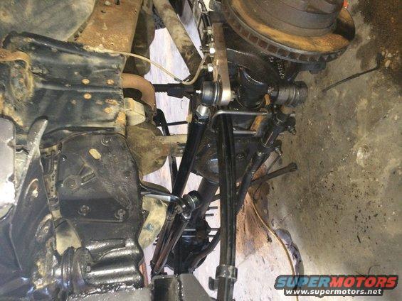 Underside suspension parts, rusty metal, black components, and a tire