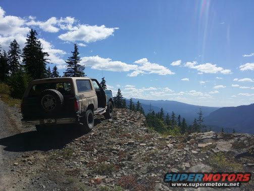 1996 Ford Bronco and another SUV parked on a rocky mountain overlook with a scenic view