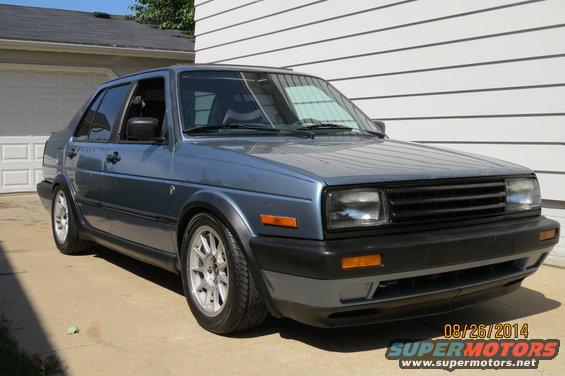Blue 1990 Volkswagen Jetta parked in front of a garage