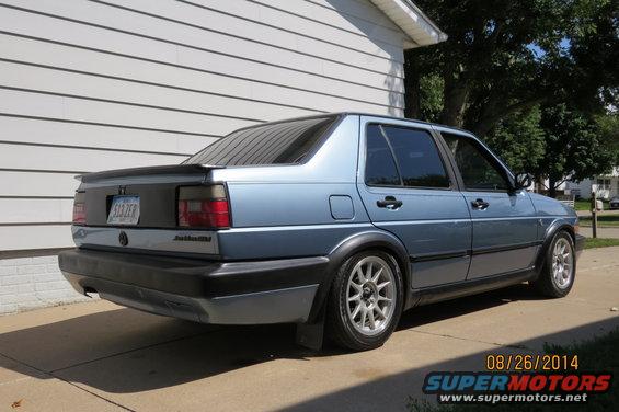 1990 Volkswagen Jetta rear view, blue sedan with aftermarket wheels