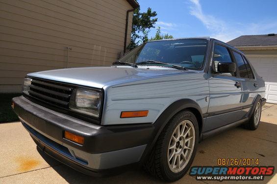 Light blue 1990 Volkswagen Jetta sedan parked in a driveway, front 3/4 view