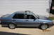 1990 Volkswagen Jetta - A blue 1990 Volkswagen Jetta is parked outside a building with a white paneled wall.