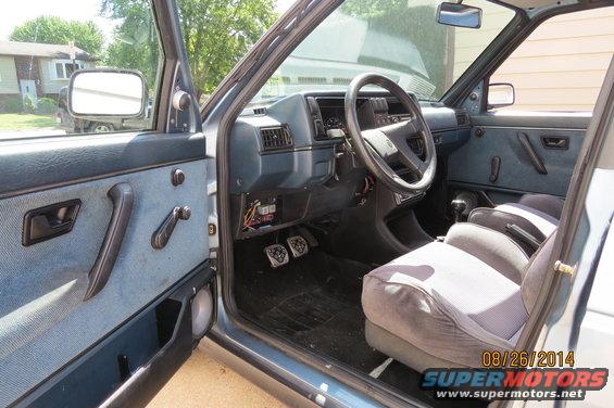 Interior of a 1990 Volkswagen Jetta showing dashboard, seats, and door panel