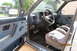 1990 Volkswagen Jetta - The interior of a 1990 Volkswagen Jetta features blue fabric seats and door panels, a dark dashboard, and a four-spoke steering wheel.