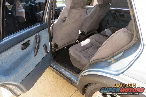 1990 Volkswagen Jetta interior showing front and rear seats, door panel, and dashboard reflection