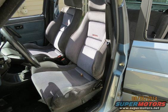 Car interior showing front seats with Recaro badging, dashboard, and door panel