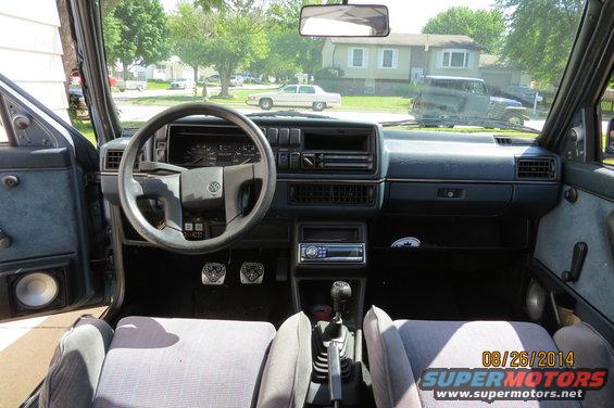 1990 Volkswagen Jetta interior with grey cloth seats, a dark dashboard, and a manual transmission shifter