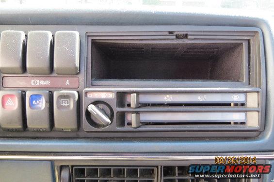 Car dashboard with buttons for brake, A/C, and defroster, plus a radio slot and climate controls