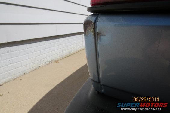 Rear quarter panel damage on a blue vehicle
