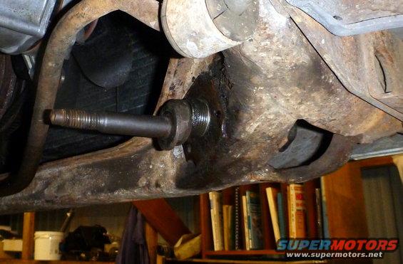 Close-up of a rusty car suspension component with a threaded stud