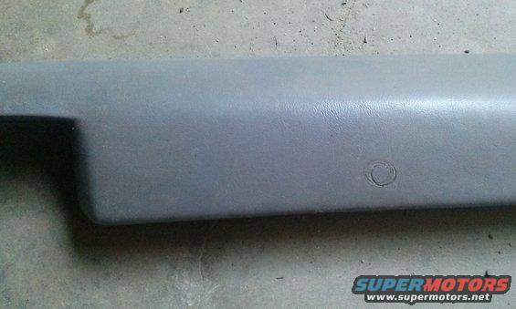 Gray plastic interior trim piece with circular indentation and Supermotors logo