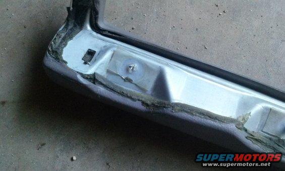 Close-up of a car door frame with visible damage and repair work. Supermotors.net logo in lower right