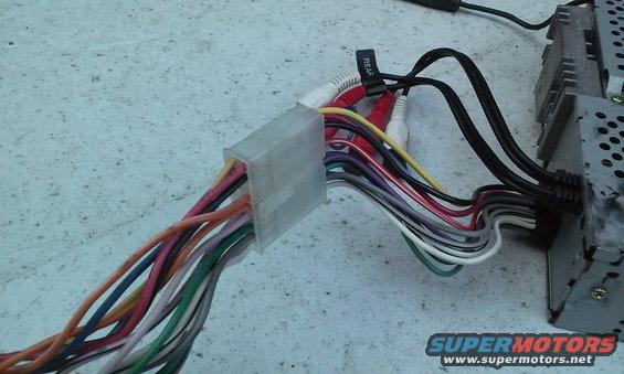 Car stereo wiring harness with RCA connectors and a black label reading 'REAR'