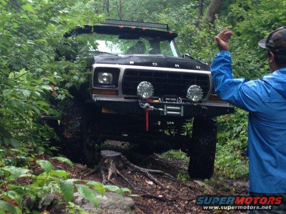Black 1979 Ford Bronco navigating a wooded trail