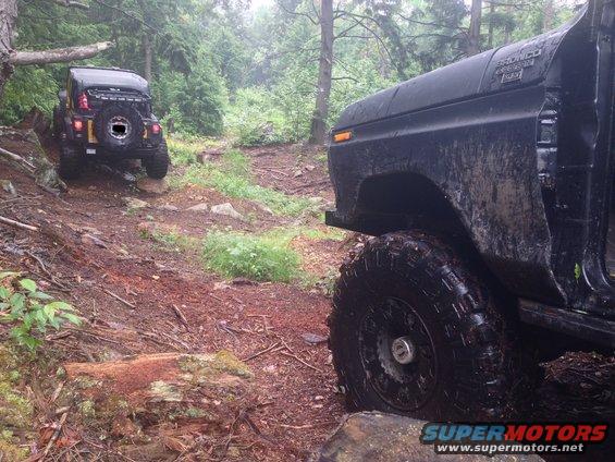 Black 1978 Ford Bronco, front quarter view, off-road tires, muddy, door removed