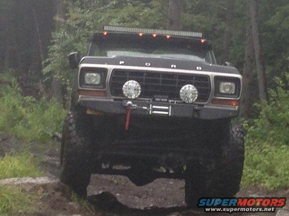 Black 1978 Ford Bronco with winch and light bar, front view, off-road