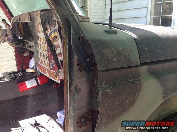 close-up of old truck interior, dash covered in newspaper, fire extinguisher on floor