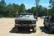 1979 Ford Bronco - A muddy Ford F-Series truck is parked outdoors with other vehicles in the background.