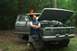 1979 Ford Bronco - A man poses with a dusty 1979 Ford Bronco, its hood raised, in a wooded area.