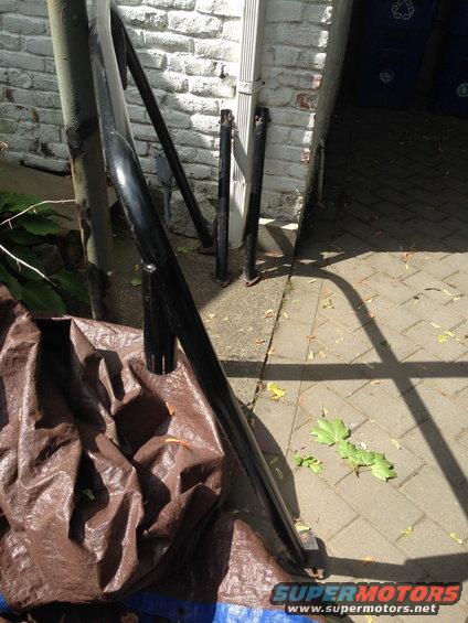 Black metal bars and tarp on paved ground