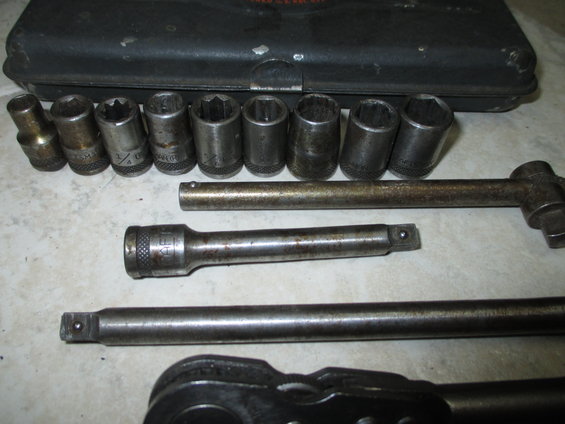 Socket wrench set with various sockets, extension, and ratchet handle. Some sockets have legible markings