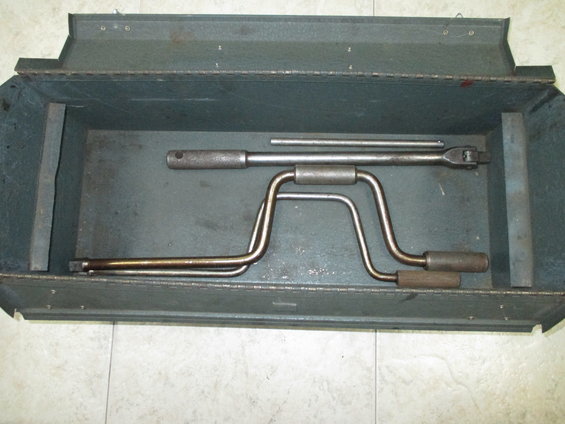 Car jack and lug wrench set inside a metal toolbox