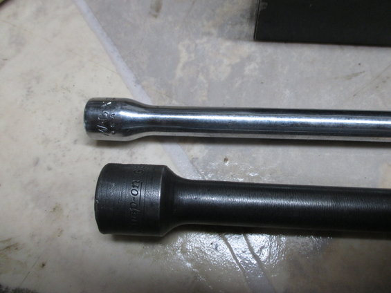 Two socket extension bars, one chrome with markings, one black with 'Snap-On' visible